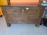 a wooden chest sitting on a tiled floor in a room