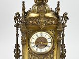 a gold clock that is sitting on a white surface
