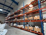 Le grand entrepôt regorge d'étagères et de palettes de marchandises.