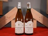 two bottles of wine sitting on a table next to each other
