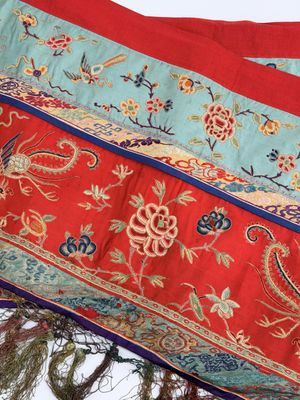 a red, blue, and green oriental rug hanging from a tree