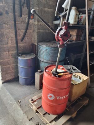 un fût rouge posé sur une palette dans un garage