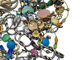 a pile of assorted jewelry on a white surface