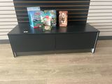 a close up of a black entertainment unit with two books on it