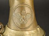 a brass bell with a bird on it