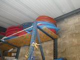 a rack with a bunch of hoses on it in a garage