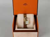 an orange box with a watch inside of it on a white surface