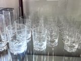 a lot of glasses that are sitting on a glass table