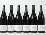 six bouteilles de vin sont alignées sur une table