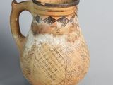a brown and white vase sitting on a gray surface