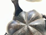a silver teapot sitting on a table next to a tea cup