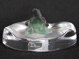 a glass figurine of a frog sitting on top of a glass plate