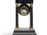 a black and gold clock with a bell on it