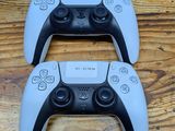 two video game controllers sitting on a wooden table