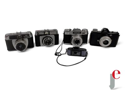 four old cameras are lined up in a row on a white surface