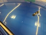 a close up of a blue car with a pair of scissors on top of it