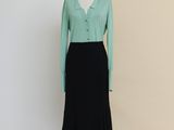 a mannequin dress with a green shirt and black skirt