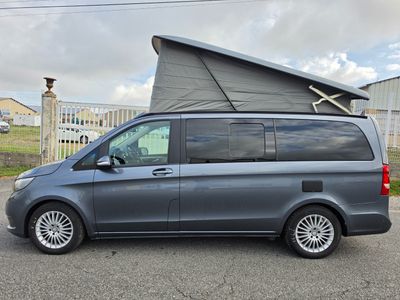 the van is parked in the parking lot with the roof up