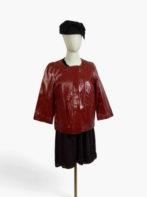 mannequin wearing a red leather jacket and skirt with a black hat