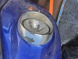 a close up of a blue motorcycle with a light on it