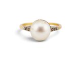 gros plan d'une bague en perles et diamants sur fond blanc