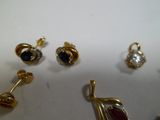 trois paires de boucles d'oreilles et un pendentif posés sur une table