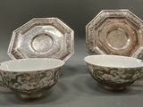 two cups and saucers are sitting side by side on a table