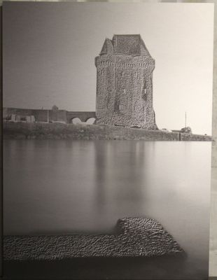 photographie en noir et blanc d'un château surplombant un plan d'eau