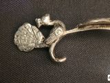 a silver brooch with a bird and a flower on it