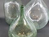 three green glass vases sitting next to each other on a table