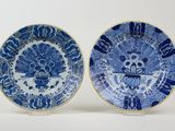 two blue and white plates with designs of birds and flowers