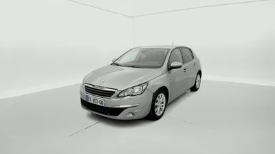 La voiture argentée est garée dans une pièce blanche au sol blanc.