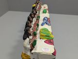 figurines of people sitting at a long table with food on it