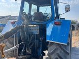 a blue tractor that is parked on the side of the road