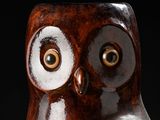 a brown owl figurine sitting on a black surface