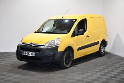 La camionnette jaune est garée dans une pièce blanche au sol carrelé en damier.