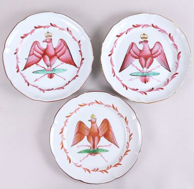 trois assiettes ornées d'oiseaux, posées sur une table