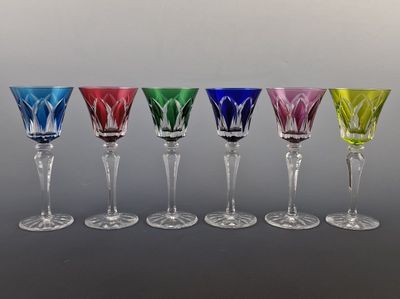 six verres à vin de couleurs différentes sont alignés