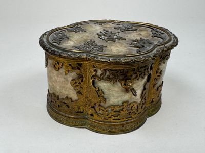 une boîte dorée et blanche posée sur une surface blanche