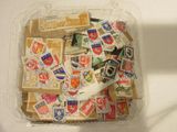 un récipient en plastique rempli de timbres et une paire de ciseaux