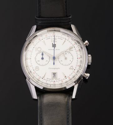 a close up of a watch on a black surface with a black background
