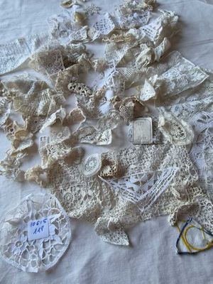 beaucoup de napperons sur une table, avec une paire de ciseaux