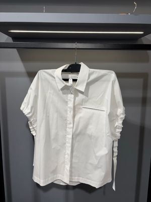 une chemise blanche suspendue à un cintre dans une armoire