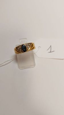 an image of a gold ring with a blue stone on it