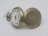 a silver pocket watch that is sitting on a white surface