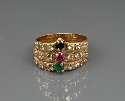 a close up of a gold ring with three different colored stones