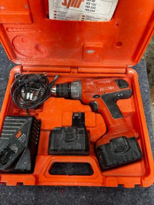 une boîte à outils orange contenant une perceuse et deux batteries