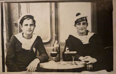 two women sitting at a table with a plate of food in front of them