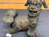 bronze statue of a dog with wings on a blue surface