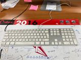 a computer keyboard and mouse on a desk with a lot of notes on it
